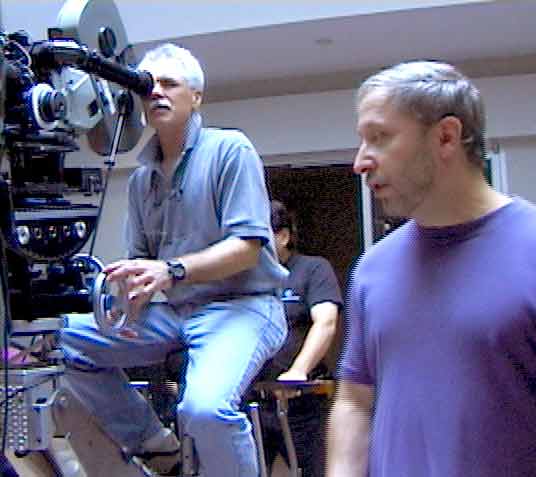 Sheldon Richman on set with a cameraman at a film camera